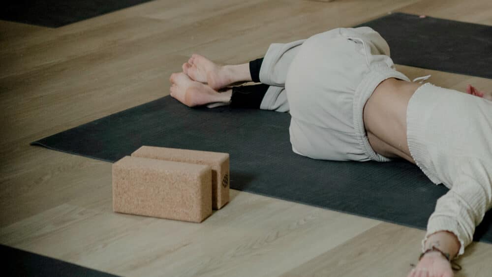 Joogaaja makaa kierrossa barajoogan pehmeässä valaistuksessa, luoden mahdollisimman rentouttavan asennon.