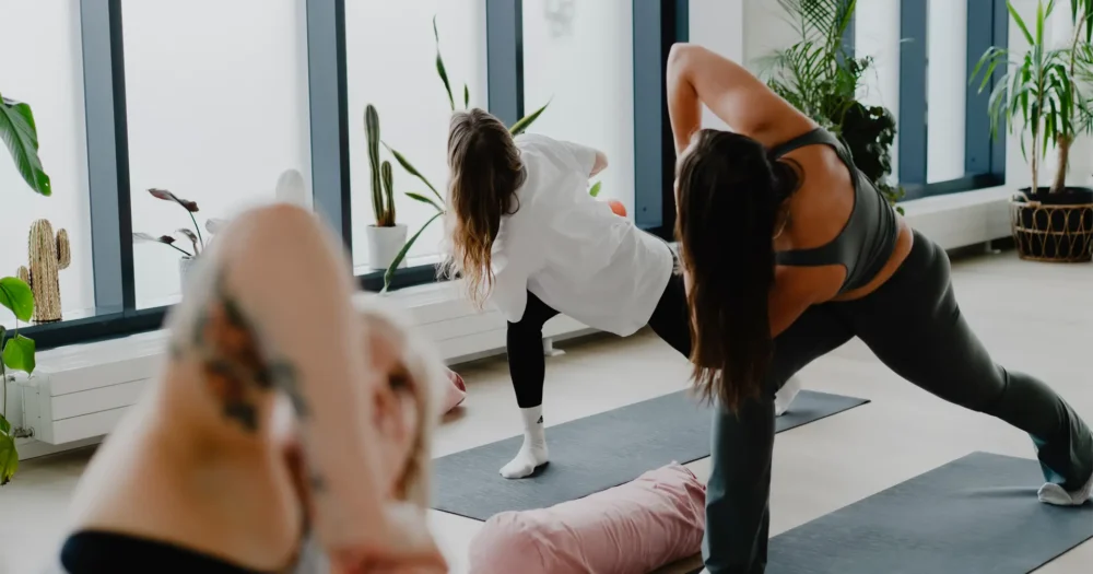 Joogaaja tekee aamujoogaa valoisassa studiossa, virtaavassa harjoituksessa, jossa hengitys ja liike herättävät kehon lempeästi uuteen päivään.